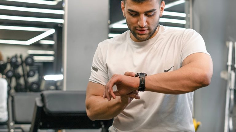 Man checking smartwatch in a gym.